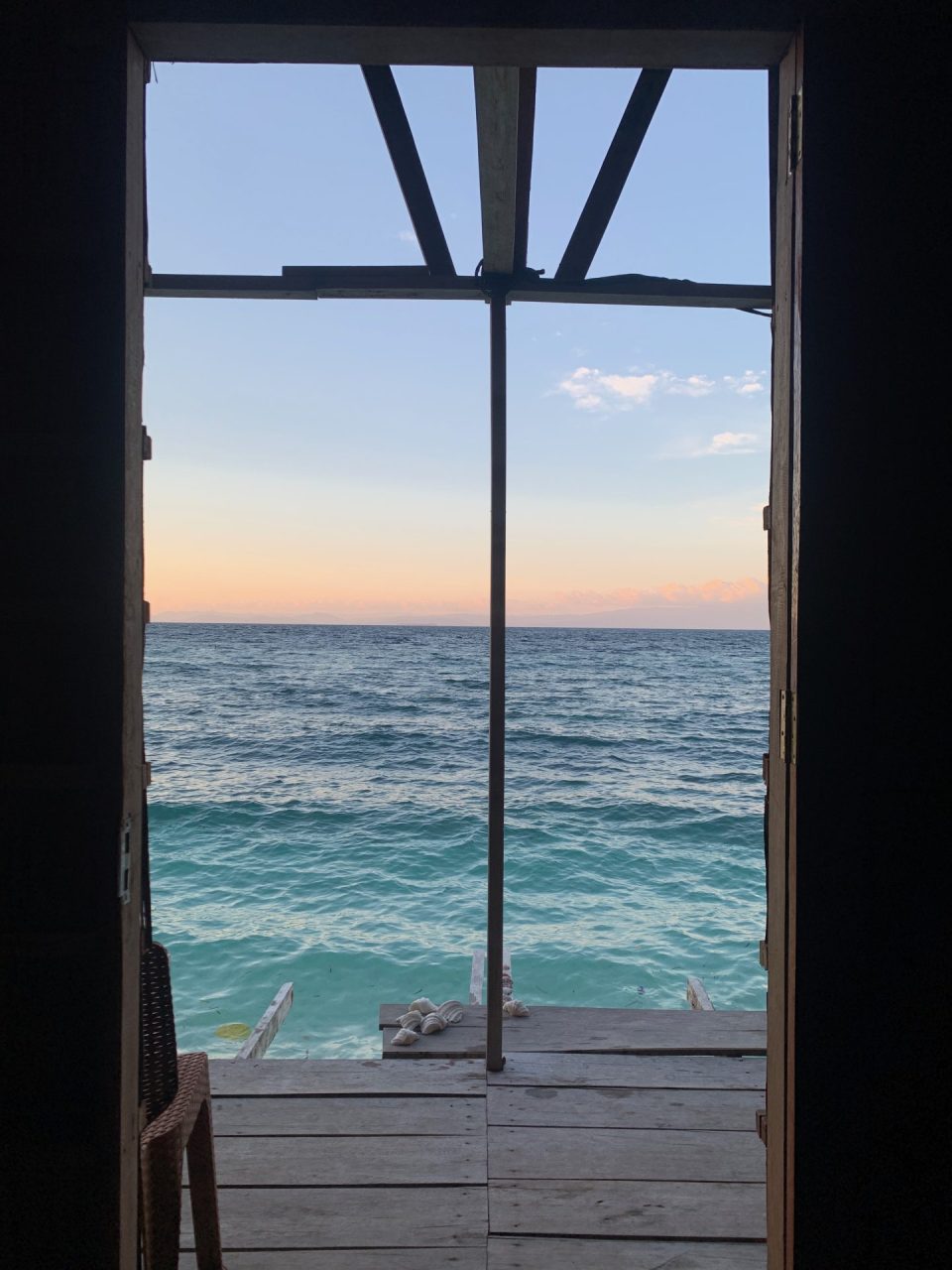 View of the ocean through open door in bungalow. Raja Ampat, Indonesia.