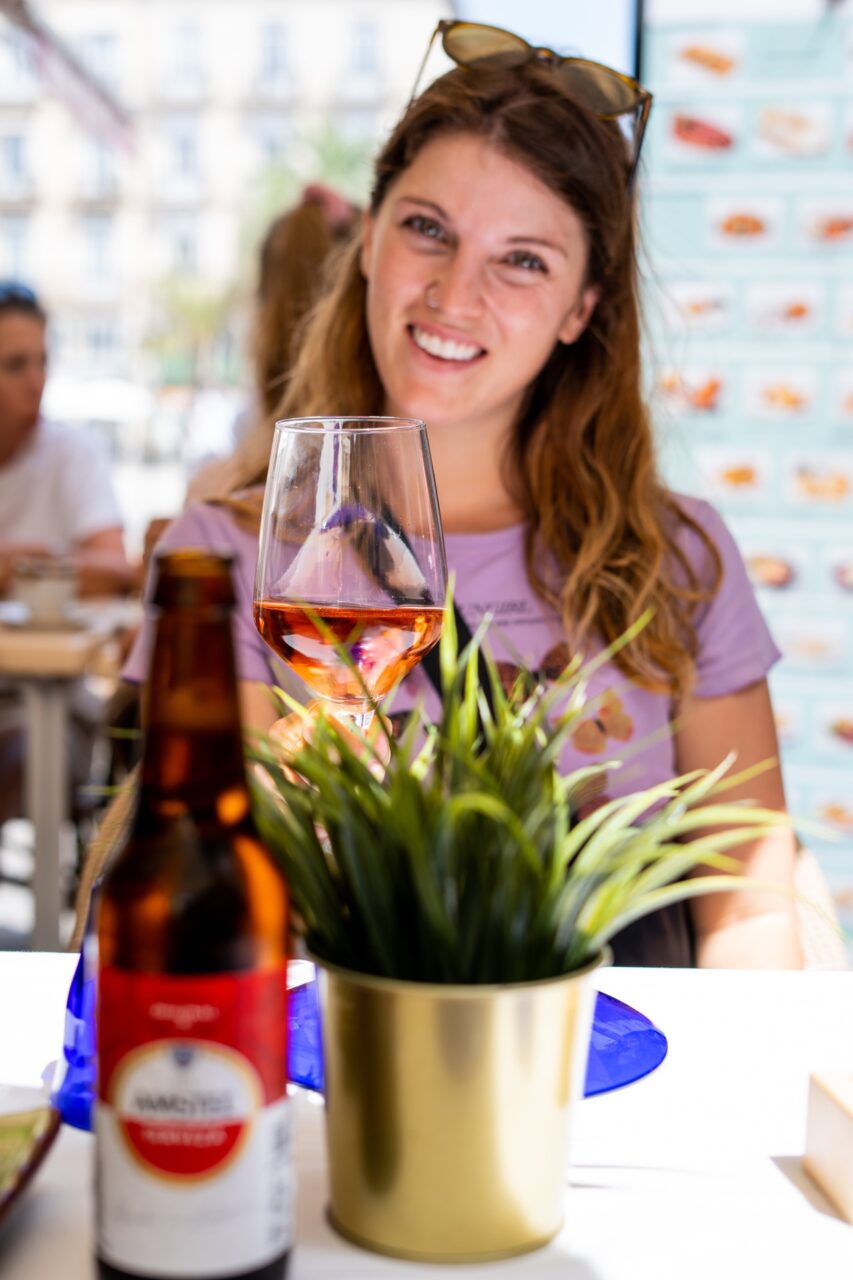 Woman sips Spanish rosé wine on a outdoor patio in Plaça de la Verge square in Valencia, Spain