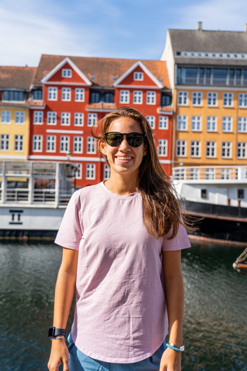 Woman in front of Nyhavn canal in as a stop in Copenhagen, Denmark