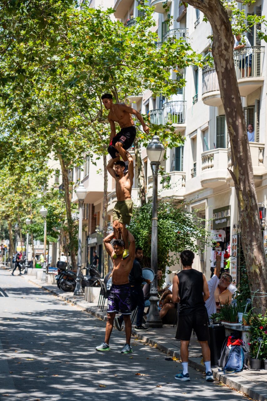 Male street dancers performing gravity defying tricks near Sagrada Familia in Barcelona, Spain