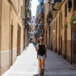 Backpacker girl walking through the quaint streets of Barcelona, Spain.