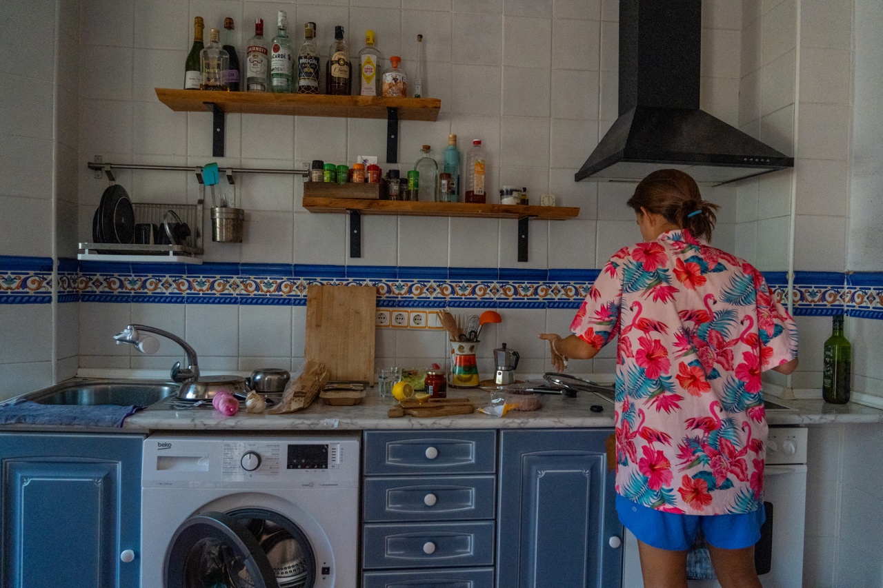 Woman in Hawaiian shirt cooking in a blue kitchen in Valencia, Spain
